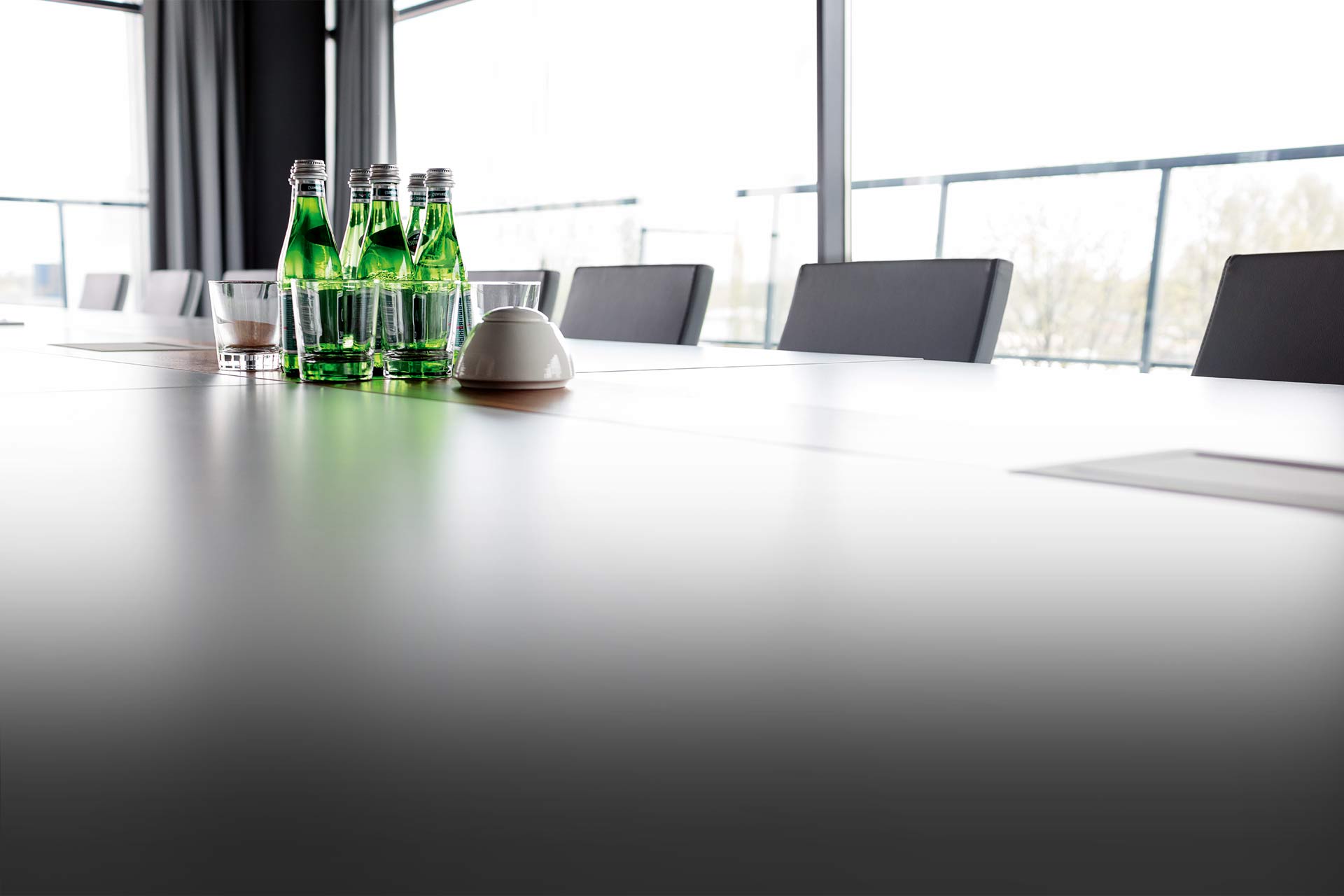Ein blank geputzter Konferenztisch mit Mineralwasserflaschen